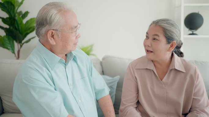 亚洲护士或医生在家中向老年妇女和老年男子解释治疗。一起谈论健康。