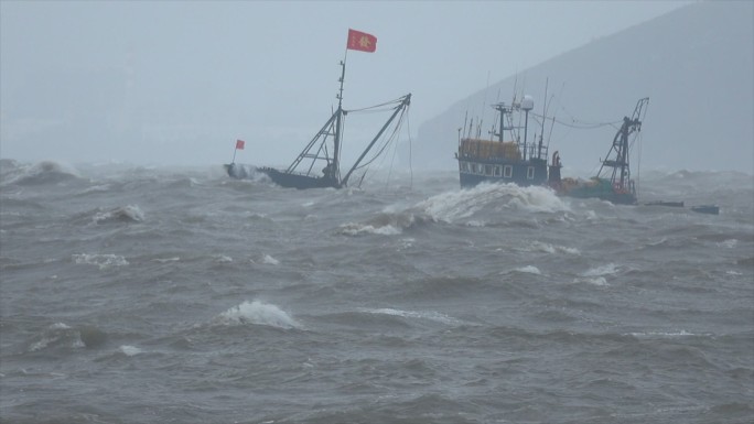 大浪中逆行的渔船 台风天海上航行的渔船