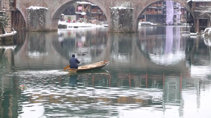 一个男人在沱江中划船 冬天 下雪 凤凰