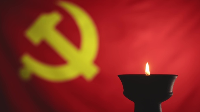 蜡烛烛光映照下鲜艳的红色中国共产党党旗