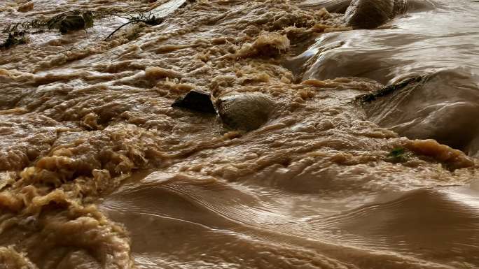 急流搅动泥沙，使河水变成褐色