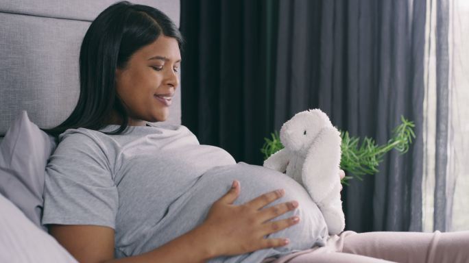 一名年轻孕妇在家里向玩具介绍自己的婴儿肿块的4k视频片段