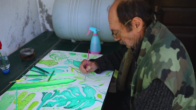活跃的退休者用树叶符号给他的艺术产品着色