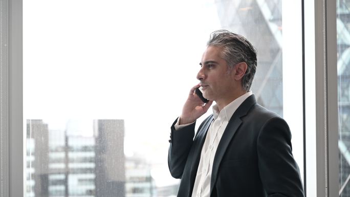 伦敦金融家在现代办公室使用智能手机交谈