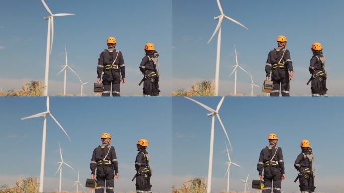 两名身着制服的亚洲工程师正在泰国风电场准备一台安全的风力涡轮机并进行进度检查。