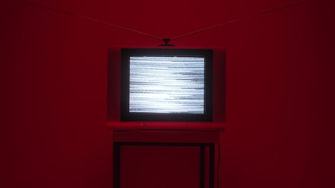 在深红色背景上，画面中间有电视屏幕噪音的电视