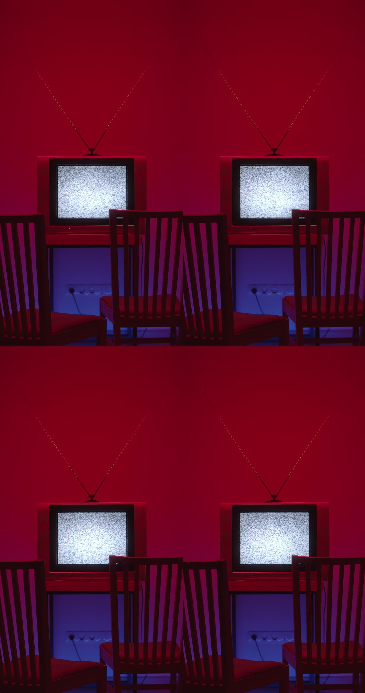 在一个黑暗的房间里，一个电视静态噪音的垂直视频在画面的中间，前面有两把椅子