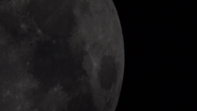 通过望远镜观察黑色夜空中的月亮