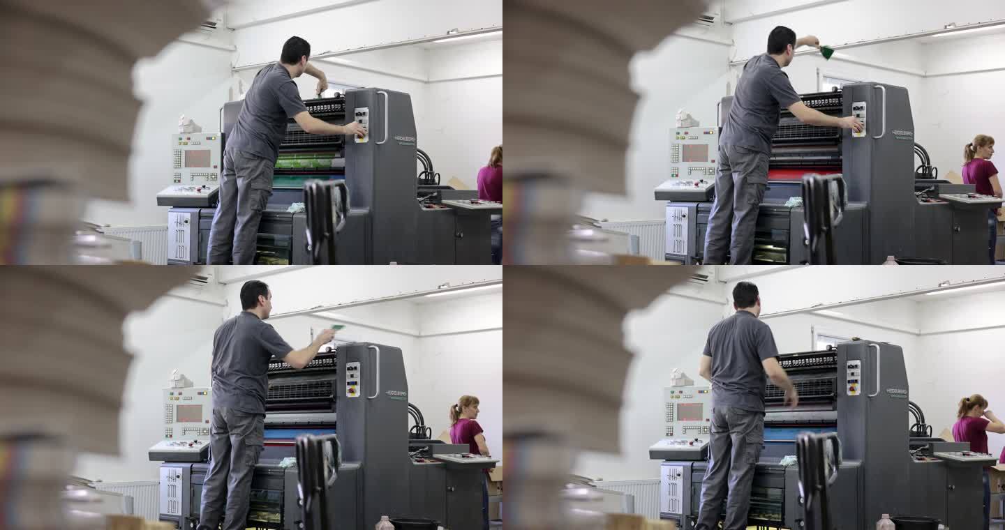 印刷厂工人正在调整自动印刷机