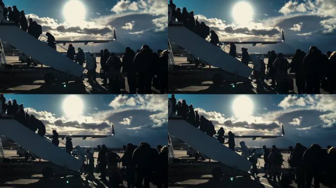 未被识别的乘客和侧影登上飞机的梯子，人们爬上飞机的坡道