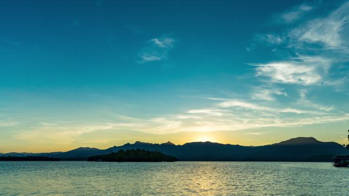 日落时山和湖的宁静场景，从白天到黄昏的延时视频