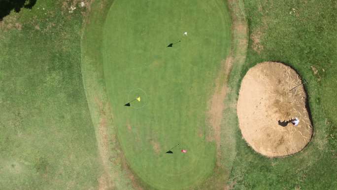 在高尔夫球场上打高尔夫球的人的鸟瞰图，打高尔夫的人休闲活动绿色高尔夫球场