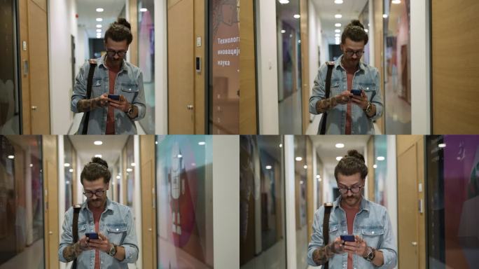一名大学生在移动中，穿过走廊，使用他的智能手机