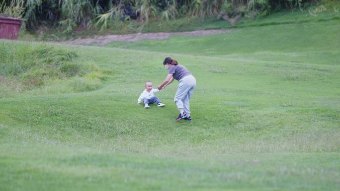 母亲带孩子在草坪上玩耍