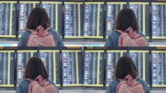 一位女士正在看国际机场的航班信息牌