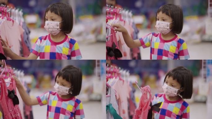 一个戴着口罩的亚洲女孩走在当地的超市里，看着货架上的产品。
