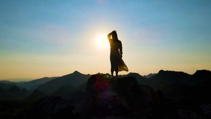 山顶女孩眺望触摸太阳阳光穿过指尖登上山顶