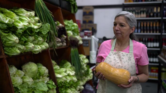 一位在蔬菜水果市场工作的高级女士正在安排展示