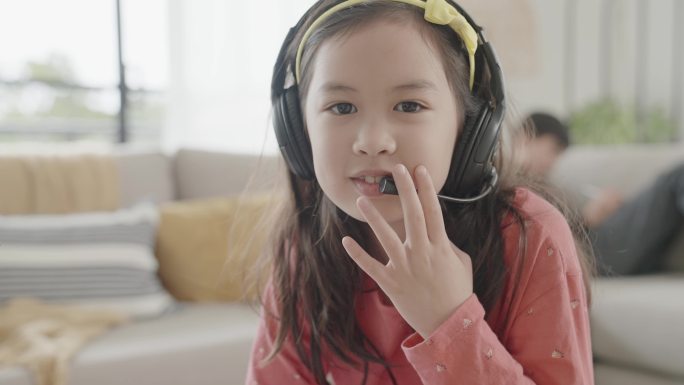 混合亚洲女孩在家用笔记本电脑进行视频通话，使用zoom在线虚拟课堂，社交距离，家庭教育，电子学习，新