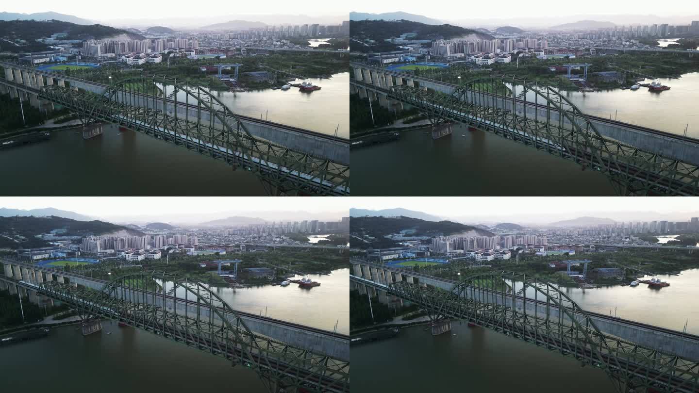 高速列车通过城市河上火车桥的鸟瞰图
