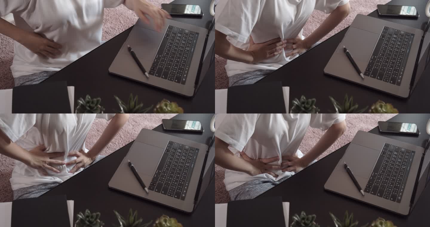 一名亚洲女性在家远程使用笔记本电脑时出现骨盆疼痛和胃痛