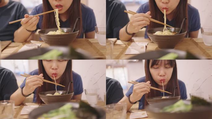 一位年轻女子正在吃拉面，一种日本面条汤。