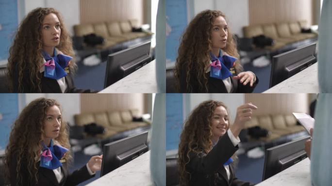 微笑的高加索女航空公司工作人员在机场的值机柜台向旅客致意