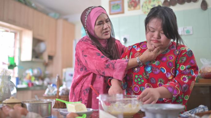 马来西亚母亲和她的唐氏综合症女儿在厨房制作传统马来甜点