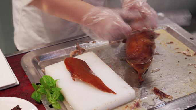 厨师在案板上切北京烤鸭