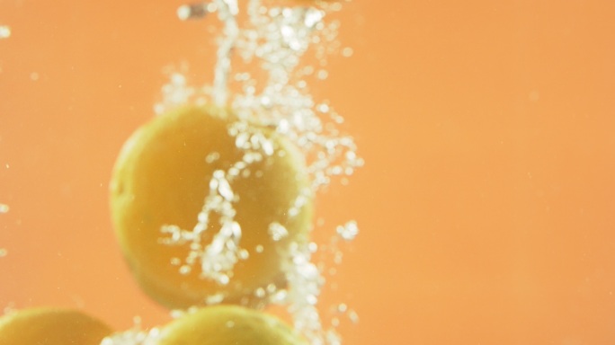 新鲜的橘子和葡萄柚正在清洗，以去除待清洗的农药。清爽的柑橘类水果浸没在飞溅、起泡的水中，四处漂浮。用
