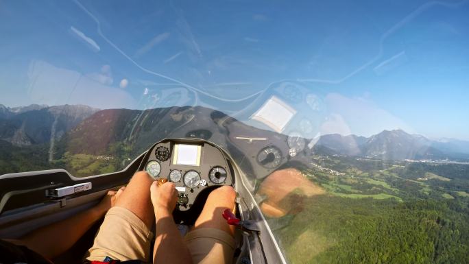 在阳光明媚的日子里，当一架轻型飞机将滑翔机拖到空中时，飞行员控制滑翔机