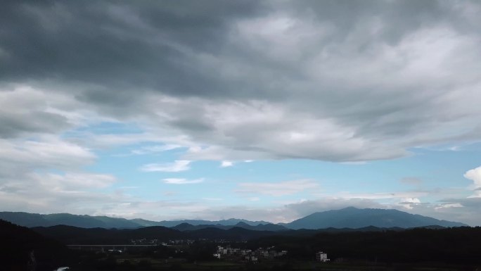 4K航拍乌云下的村庄动态天空素材视频