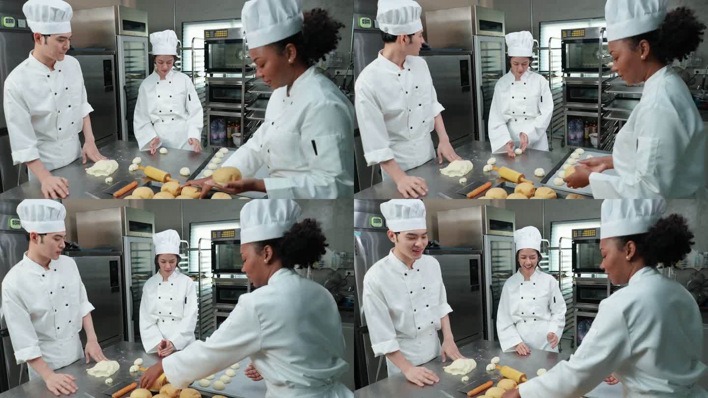 穿着白色制服的快乐的多种族青年厨师们一起工作，制作面包、面包和法式面包，在烤箱中打样和烘烤之前进行一