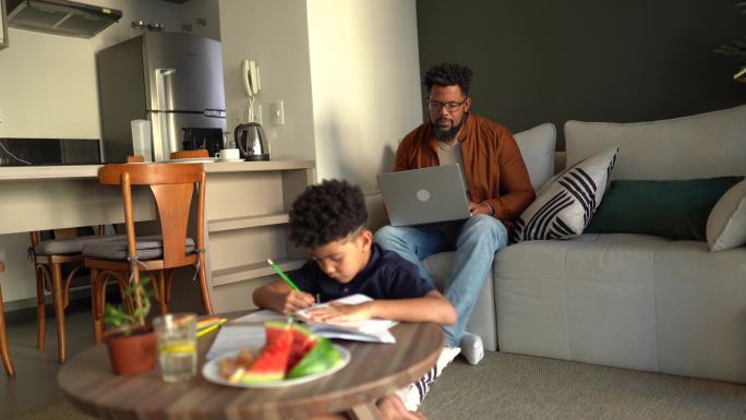 男孩和父亲一起学习，在家做背景工作