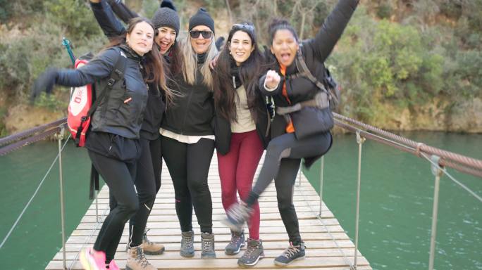 一群女性朋友在吊桥上拍照。