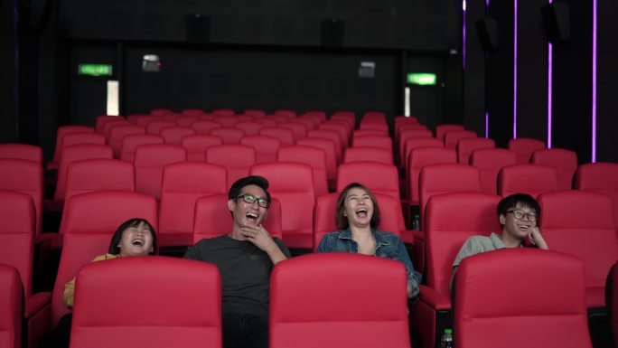 周末，亚裔中国家庭在电影院看电影。