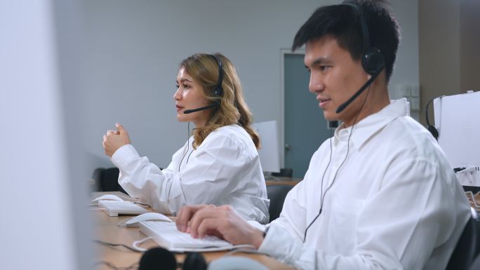 亚洲呼叫中心团队、客户服务、电话销售人员戴着耳机或耳机在现代办公室与客户交谈
