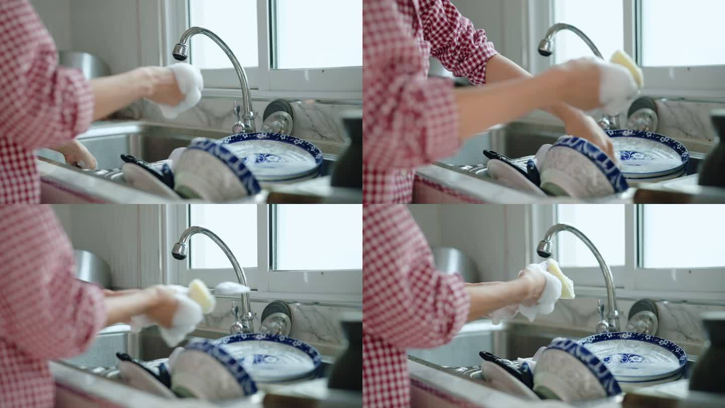 女人在家里洗碗。厨房用餐后清洗
