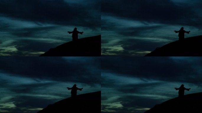《剪影》中的耶稣基督在日出日落的山坡上跪下祈祷