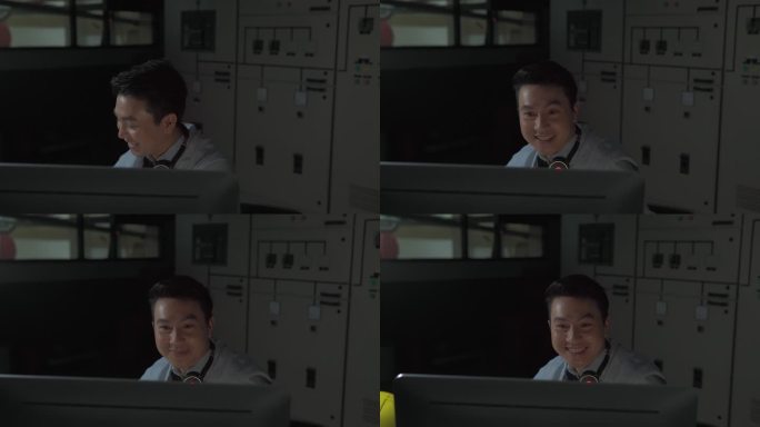在控制室操作个人电脑的英俊工程师的肖像。