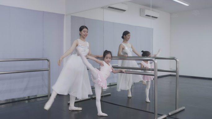 芭蕾舞学校的老师帮助年轻的芭蕾舞演员进行不同的舞蹈练习。他们在芭蕾舞课上排练。老师和孩子们交流。