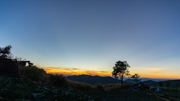 日落在农场和山上露营地上空的延时拍摄