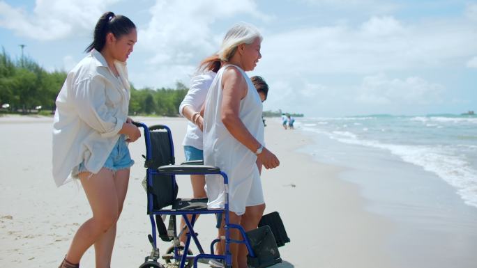 快乐亚洲家庭在海滩享受海浪、度假、放松、度假、退休、轮椅