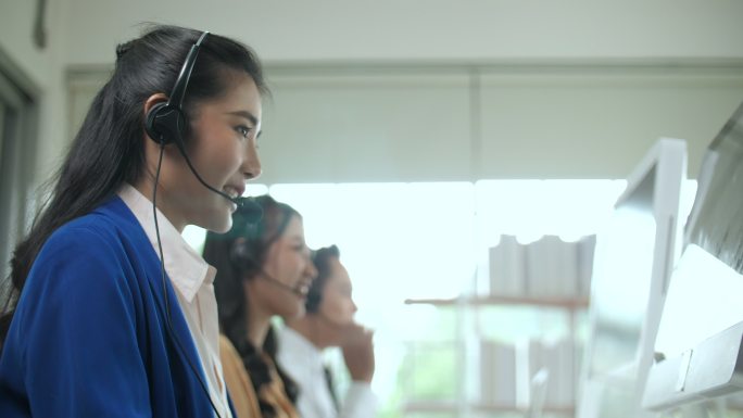 年轻的女性呼叫中心代理在她的工作站上与客户交谈