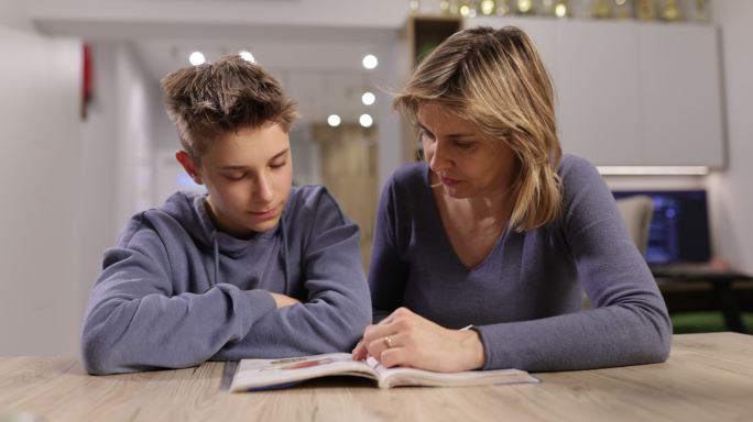 妈妈帮儿子做作业教导辅导孩子检查孩子作业