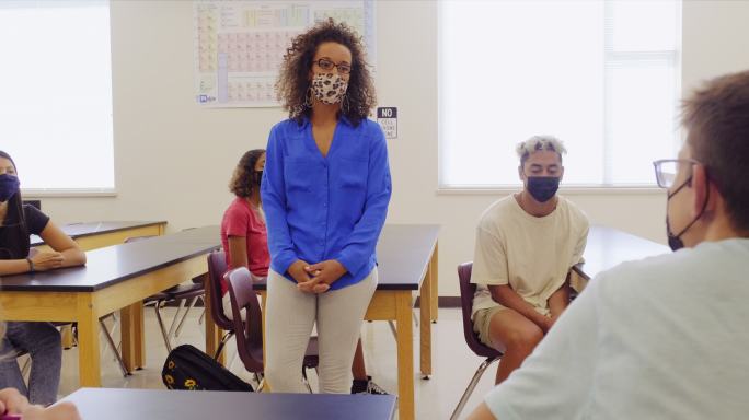 高中教师和学生在教室里戴防护口罩
