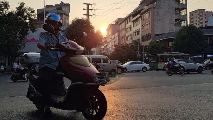 夕阳西下落日黄昏上下班人群摩托车电车大军