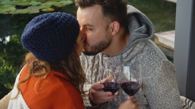 情侣们喝着红酒，在院子里亲吻