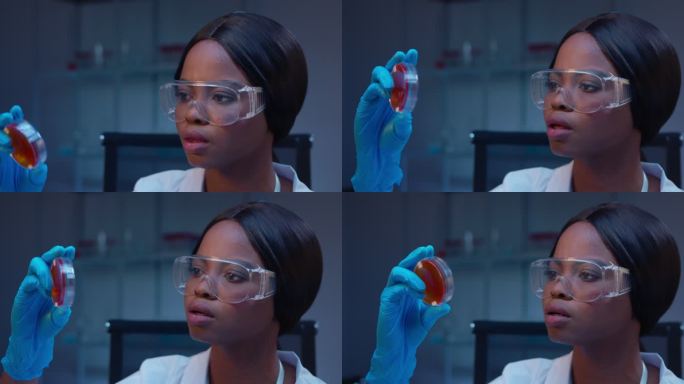 一位年轻的非洲裔美国女性微生物学家正在观察一个细菌生长的小型培养皿
