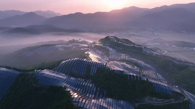 新能源太阳能光伏发电站夕阳下山坡航拍